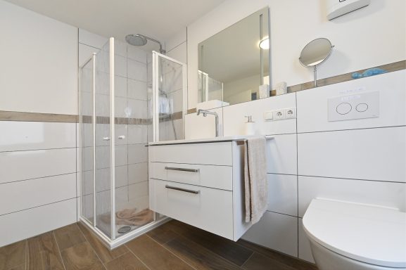 Badezimmer mit bodentiefer Dusche. Badezimmer mit bodentiefer Dusche und Regenbrause.